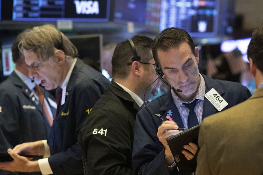Stock traders work at the New York Stock Exchange, Tuesday, March 17, 2020 in New York. (AP Photo/Mark Lennihan)