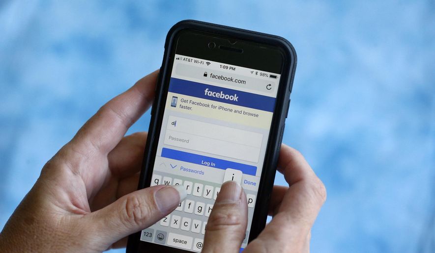 In this Aug. 21, 2018, file photo, a Facebook start page is shown on a smartphone in Surfside, Fla. Facebook says a bug in its anti-spam system is blocking the publication of links to news stories about the coronavirus. (AP Photo/Wilfredo Lee, File)