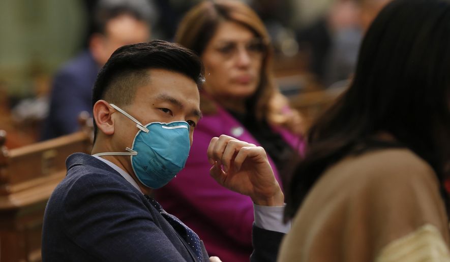 Assemblyman Evan Low, D-San Jose, wears a mask as listens to lawmakers discuss a pair of bills dealing with the coronavirus at the Capitol in Sacramento, Calif., Monday, March 16, 2020. Low, whose district encompasses Santa Clara County that has had 79 confirmed cases of the coronavirus, wore the mask as precaution. (AP Photo/Rich Pedroncelli) **FILE**