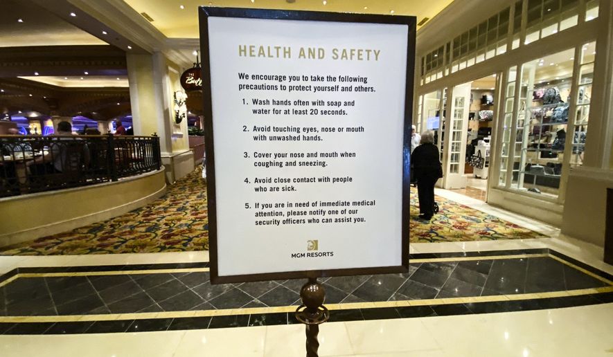 A health and safety sign is posted inside of the Beau Rivage Resort and Casino as patrons come onto the floor, in Biloxi, Miss., Monday, March 16, 2020. All of Mississippi's state-regulated casinos were ordered to close by midnight Monday to limit the spread of the new coronavirus. More than 16,400 employees work in the 26 casinos, which are strong tourist attractions. (Alyssa Newton/The Sun Herald, via AP)