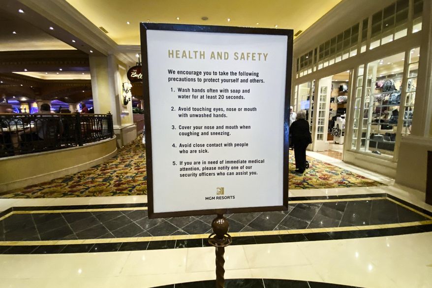 A health and safety sign is posted inside of the Beau Rivage Resort and Casino as patrons come onto the floor, in Biloxi, Miss., Monday, March 16, 2020. All of Mississippi's state-regulated casinos were ordered to close by midnight Monday to limit the spread of the new coronavirus. More than 16,400 employees work in the 26 casinos, which are strong tourist attractions. (Alyssa Newton/The Sun Herald, via AP)