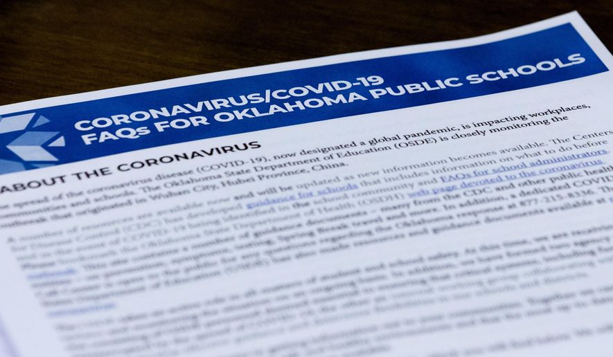 Paperwork presented to members of the State Board of Education is viewed during Oklahoma's State Superintendent of Public Instruction Joy Hofmeister's emergency meeting of the Oklahoma State Department of Education in Oklahoma City, Monday, March 16, 2020, to announce the closing of public school till April 6 to combat the spread of the coronavirus. (Chris Landsberger/The Oklahoman via AP)