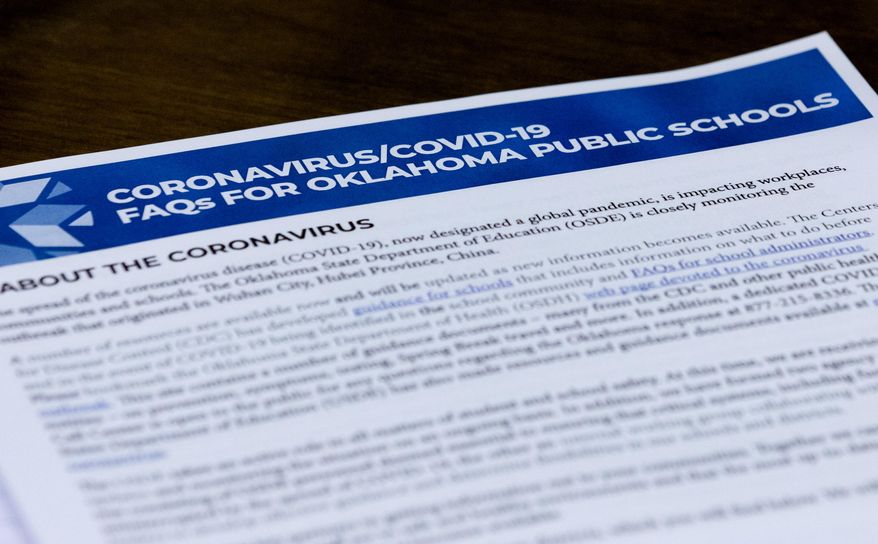 Paperwork presented to members of the State Board of Education is viewed during Oklahoma's State Superintendent of Public Instruction Joy Hofmeister's emergency meeting of the Oklahoma State Department of Education in Oklahoma City, Monday, March 16, 2020, to announce the closing of public school till April 6 to combat the spread of the coronavirus. (Chris Landsberger/The Oklahoman via AP)