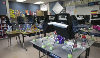 Student&#x27;s chairs are stacked on top of desks in an empty classroom at closed Robertson Elementary School, March 16, 2020, in Yakima, Wash. (Amanda Ray/Yakima Herald-Republic via AP)