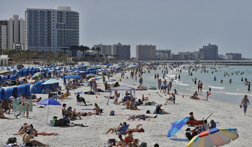 Visitors enjoy Clearwater Beach, Wednesday, March 18, 2020, in Clearwater Beach, Fla. Beachgoers are trying to keep a safe distance from each other by keeping a space of 6 to 10 feet (2 to 3 meters) between family groups to help protect from the spread of the coronavirus. (AP Photo/Chris O'Meara)