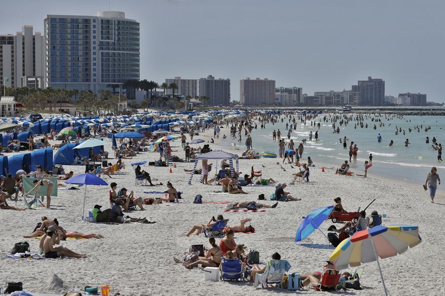 Visitors enjoy Clearwater Beach, Wednesday, March 18, 2020, in Clearwater Beach, Fla. Beachgoers are trying to keep a safe distance from each other by keeping a space of 6 to 10 feet (2 to 3 meters) between family groups to help protect from the spread of the coronavirus. (AP Photo/Chris O'Meara)