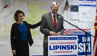 Judy Lipinski touches the back of her husband U.S. Rep. Dan Lipinski as he concedes the Democratic primary election to Progressive Marie Newman during a press conference at his election headquarters in Oak Lawn, Ill., Wednesday afternoon, March 18, 2020. (Ashlee Rezin Garcia/Chicago Sun-Times via AP)