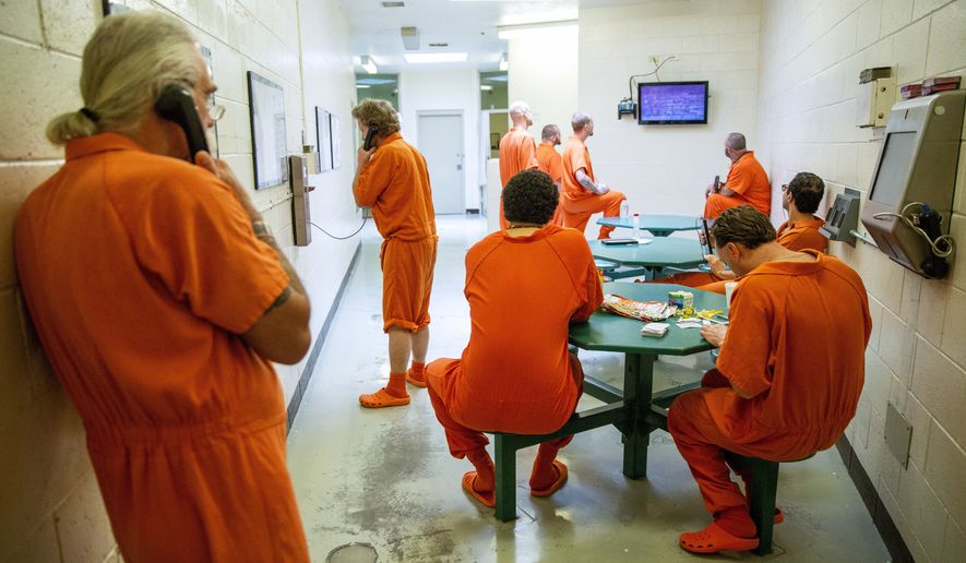 FILE - In this Friday, July 13, 2018 file photo, inmates pass the time within their cell block at the Twin Falls County Jail in Twin Falls, Idaho. In March 2020, the COVID-19 coronavirus and its lingering threat has become a potential “get out of jail card” for inmates who argue it’s not a matter of if but when the deadly illness sweeps through tightly packed populations behind bars. (Pat Sutphin/The Times-News via AP)