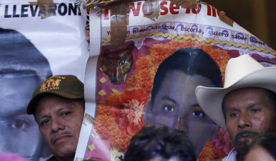 Parents and relatives of the 43 missing teachers college students hold banners depicting their loved ones as they give a press conference at the national palace in Mexico City, Thusday, Jan. 9, 2020. Family members met with Mexico's President Andres Manuel Lopez Obrador for to call for justice more than five years after the Ayotzinapa students were allegedly taken from buses by local police and turned over to a drug gang. (AP Photo/Marco Ugarte)
