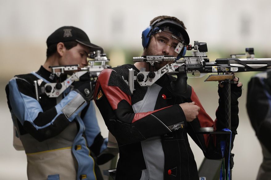 Lucas Kozeniesky of the U.S., right, competes on his way to winning gold in the men&#39;s 10-meter air rifle shooting final at the Pan American Games in Lima, Peru, Friday, Aug. 2, 2019. (AP Photo/Rebecca Blackwell)