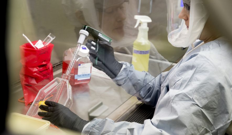 Laboratory Scientist Andrea Luquette cultures coronavirus to prepare for testing at U.S. Army Medical Research and Development Command at Fort Detrick in Frederick, Md., Thursday, March 19, 2020, where scientists are working to help develop solutions to prevent, detect and treat the coronavirus. (AP Photo/Andrew Harnik)