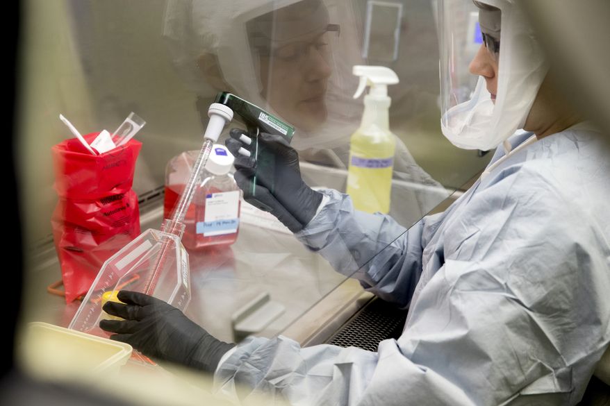 Laboratory Scientist Andrea Luquette cultures coronavirus to prepare for testing at U.S. Army Medical Research and Development Command at Fort Detrick in Frederick, Md., Thursday, March 19, 2020, where scientists are working to help develop solutions to prevent, detect and treat the coronavirus. (AP Photo/Andrew Harnik)