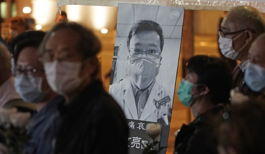 In this Feb. 7, 2020, file photo, people wearing masks attend a vigil for Chinese doctor Li Wenliang, who was reprimanded for warning about the outbreak of the new coronavirus, in Hong Kong. China has taken the highly unusual move of exonerating the doctor who was reprimanded for warning about the coronavirus outbreak and later died of the disease. An official media report said police in Wuhan had revoked its admonishment of Dr. Li that had included a threat of arrest and issued a “solemn apology&quot; to his family. (AP Photo/Kin Cheung, File) **FILE**