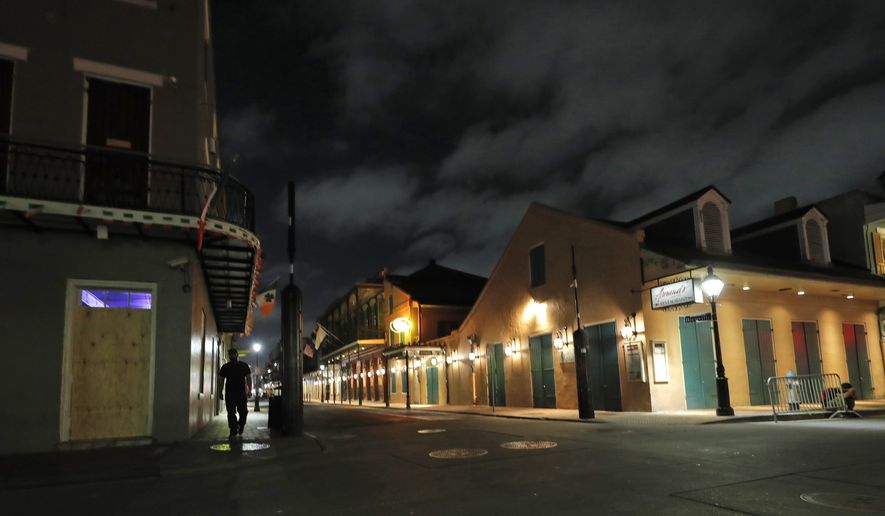 The nearly deserted Bourbon Street, which is normally bustling with tourists and revelers, stands in the French Quarter of New Orleans, Thursday, March 19, 2020. Louisiana Gov. John Bel Edwards and New Orleans Mayor Latoya Cantrell have ordered all restaurants and bars to close except for takeout, and asked residents to remain home and maintain social distancing from others when outside, due to the COVID-19 virus pandemic. (AP Photo/Gerald Herbert)