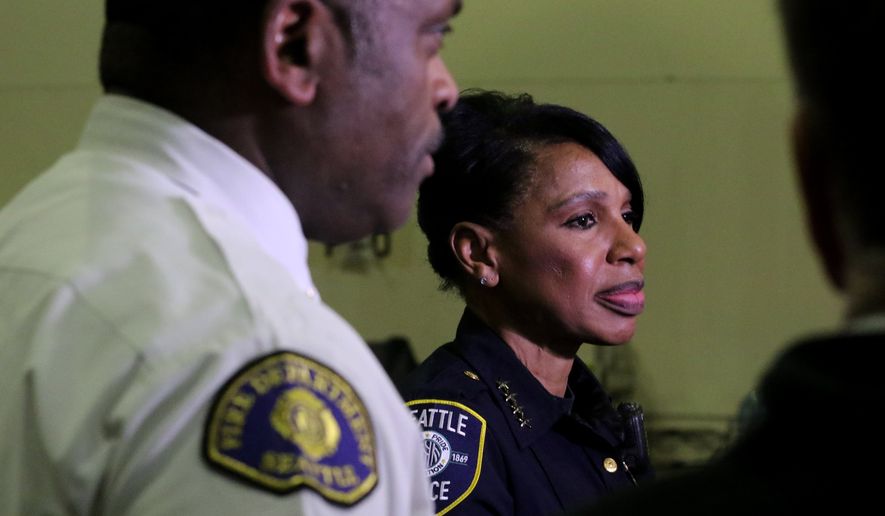 Seattle Police Chief Carmen Best and Seattle Fire Chief Harold Scoggins take questions about the drive-through testing site for first responders Thursday March 19, 2020, in Seattle, Wash. (Alan Berner/The Seattle Times via AP)