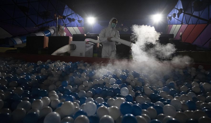 A worker sprays disinfectant as a precaution against the new coronavirus on ball pool for Kids Cinema at Quartier Cineart movie theater in Bangkok, Thailand, Thursday, March 19, 2020. Thailand's government has enacted stronger measures to combat the spread of the coronavirus, including postponing the country's biggest holiday, shutting down schools, movie theaters and closing bars. For most people, the new coronavirus causes only mild or moderate symptoms. For some it can cause more severe illness. (AP Photo/Sakchai Lalit)