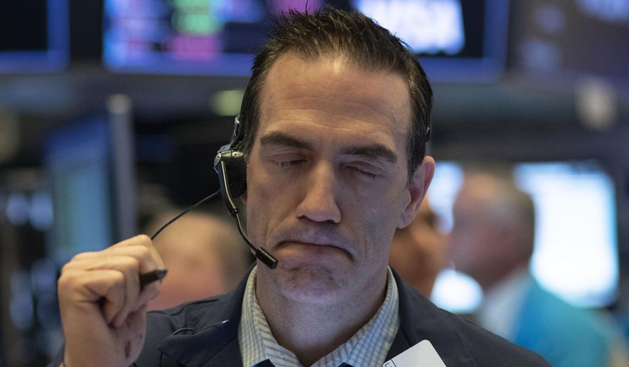 FILE - In this Wednesday, March 18, 2020, file photo, trader Gregory Rowe works at the New York Stock Exchange, in New York. The rapidly deteriorating health of the financial markets is being driven by a contagion of fear and uncertainty about a global pandemic that's infecting the economy in ways that seemed unfathomable just a month earlier. (AP Photo/Mark Lennihan, File)