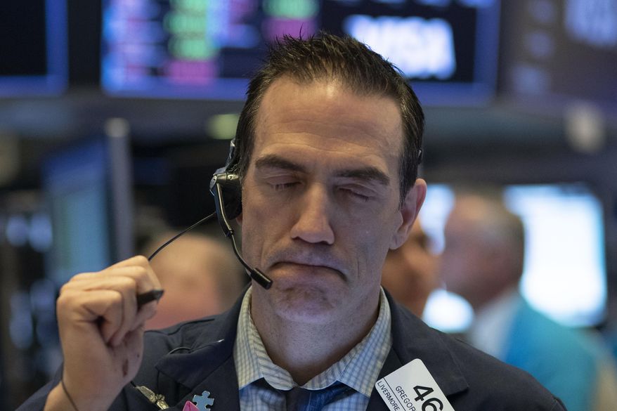 FILE - In this Wednesday, March 18, 2020, file photo, trader Gregory Rowe works at the New York Stock Exchange, in New York. The rapidly deteriorating health of the financial markets is being driven by a contagion of fear and uncertainty about a global pandemic that's infecting the economy in ways that seemed unfathomable just a month earlier. (AP Photo/Mark Lennihan, File)
