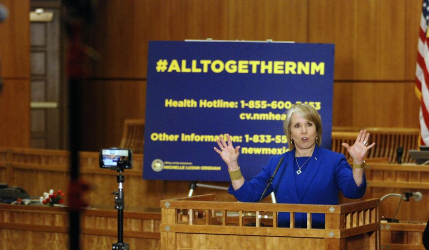 New Mexico Gov. Michelle Lujan Grisham confirmed a new coronavirus infection that has no apparent link to travel on Wednesday, March 18, 2020, during a news conference on the floor of the state House of Representatives in Santa Fe, N.M. She also issued orders to limit the spread of the contagion by restricting restaurants to take-out service and closing down movie theaters, gyms, spas and shopping malls. New Mexico is bracing for the possible spread of coronavirus to some of America's most remote, impoverished communities, as hospitals across the state prepare to convert operating rooms into acute respiratory care units. (AP Photo/Morgan Lee)