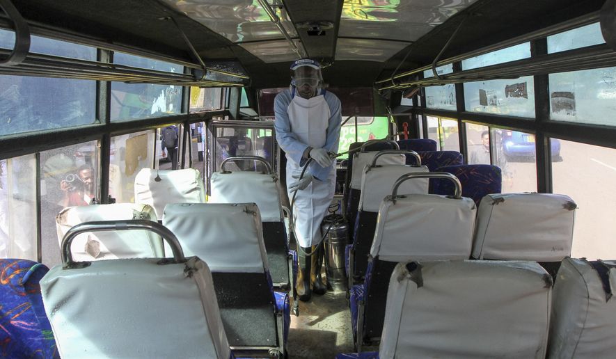 A man sprays disinfectant to sanitize a public bus against the spread of the new coronavirus, in downtown Nairobi, Kenya Thursday, March 19, 2020. For most people, the new coronavirus causes only mild or moderate symptoms such as fever and cough and the vast majority recover in 2-6 weeks but for some, especially older adults and people with existing health issues, the virus that causes COVID-19 can result in more severe illness, including pneumonia. (AP Photo)