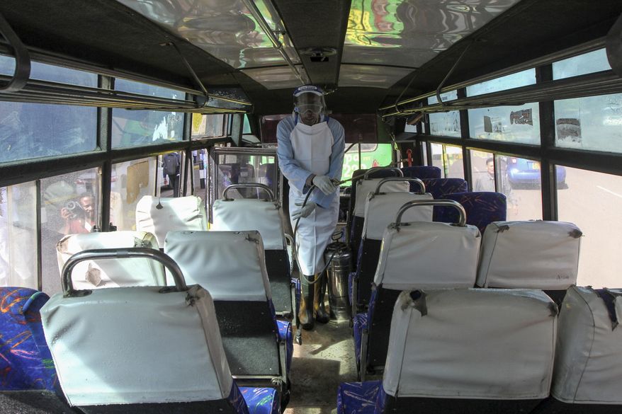 A man sprays disinfectant to sanitize a public bus against the spread of the new coronavirus, in downtown Nairobi, Kenya Thursday, March 19, 2020. For most people, the new coronavirus causes only mild or moderate symptoms such as fever and cough and the vast majority recover in 2-6 weeks but for some, especially older adults and people with existing health issues, the virus that causes COVID-19 can result in more severe illness, including pneumonia. (AP Photo)