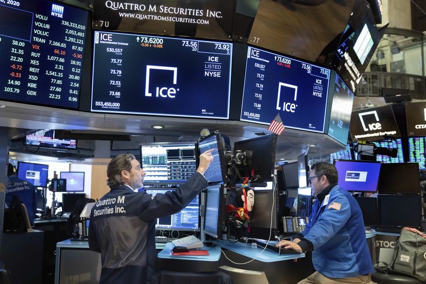 In this photo provided by the New York Stock Exchange, traders John Romolo, left, and Leon Montana work on the trading floor on Friday, March 20, 2020. Stocks turned lower Friday after New York became the latest major state to mandate nearly all workers stay home to limit the spread of the new coronavirus. (Nicole Pereira/NYSE via AP)