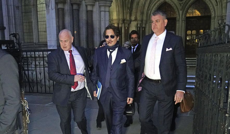 Actor Johnny Depp, center, leaves the High Court in London, after attending a preliminary hearing in his libel case against the publishers of The Sun and its executive editor, Dan Wootton, over a 2018 article alleging he had been abusive to his ex-wife Amber Heard, Wednesday, Feb. 26, 2020. (Aaron Chown/PA via AP) ** FILE **