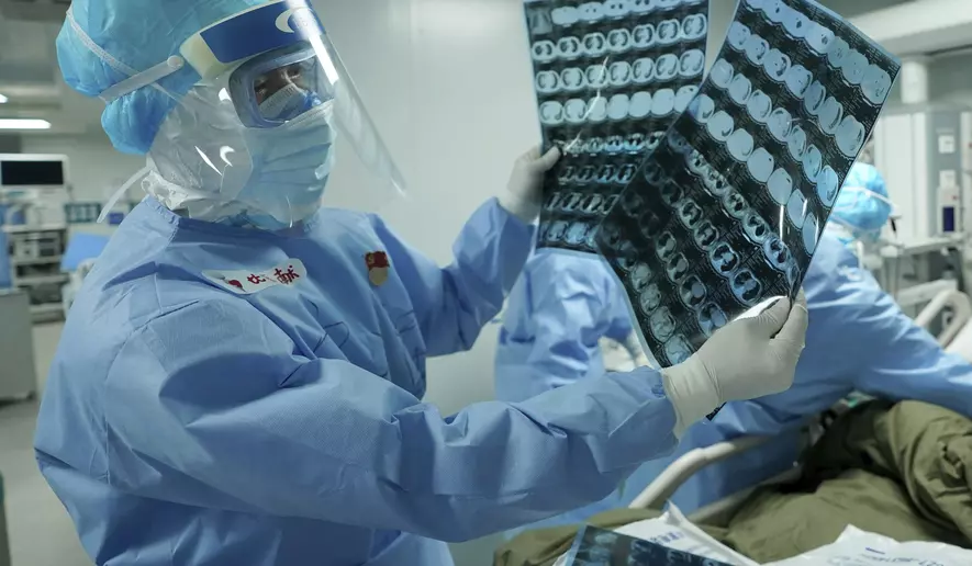 In this March 17, 2020 photo released by China&#39;s Xinhua News Agency, a medical worker looks at CT scans at the Huoshenshan field hospital in Wuhan in central China&#39;s Hubei Province. Last month, Wuhan was overwhelmed with thousands of new cases of coronavirus each day. But in a dramatic development that underscores just how much the outbreak has pivoted toward Europe and the United States, Chinese authorities said Thursday, March 19, that the city and its surrounding province had no new cases to report. The virus causes only mild or moderate symptoms, such as fever and cough, for most people, but severe illness is more likely in the elderly and people with existing health problems. (Wang Yuguo/Xinhua via AP)