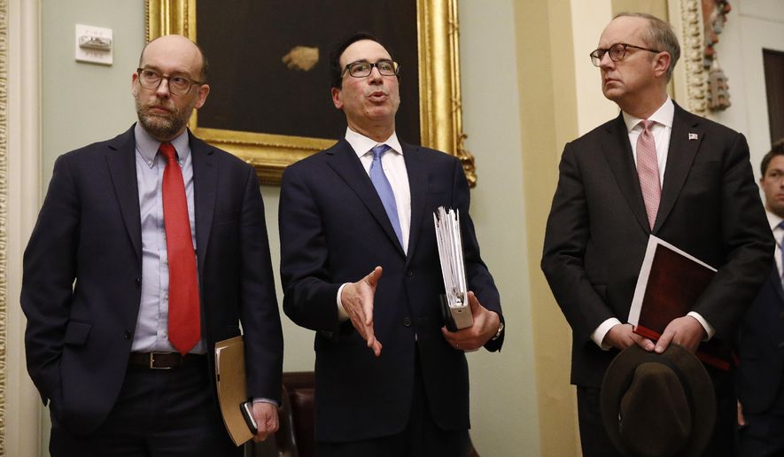 Treasury Secretary Steve Mnuchin, center, speaks with members of the media as he departs a meeting with Senate Republicans on an economic lifeline for Americans affected by the coronavirus outbreak. on Capitol Hill in Washington, Monday, March 16, 2020. (AP Photo/Patrick Semansky)