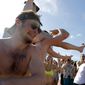 Spring break revelers party on the beach, Tuesday, March 17, 2020, in Pompano Beach, Fla. As a response to the coronavirus pandemic, Florida Gov. Ron DeSantis ordered all bars be shut down for 30 days beginning at 5 p.m. and many Florida beaches are turning away spring break crowds urging them to engage in social distancing. (AP Photo/Julio Cortez) **FILE**