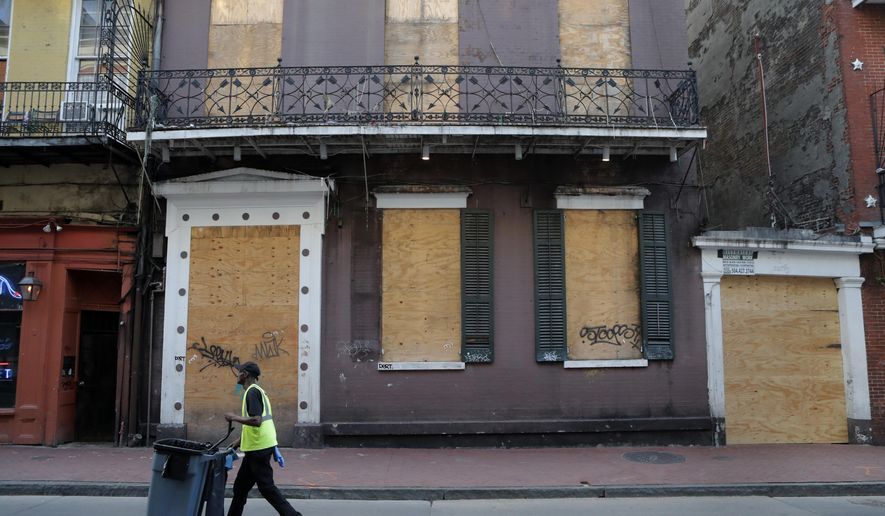 A boarded business is seen boarded up on Bourbon Street, usually bustling with tourists and revelers, in the French Quarter of New Orleans, Thursday, March 19, 2020. Louisiana Governor John Bel Edwards and New Orleans Mayor Latoya Cantrell have ordered all restaurants and bars to close except for takeout, and asked residents to remain home and maintain social distancing from others when outside, due to the COVID-19 virus pandemic. (AP Photo/Gerald Herbert)