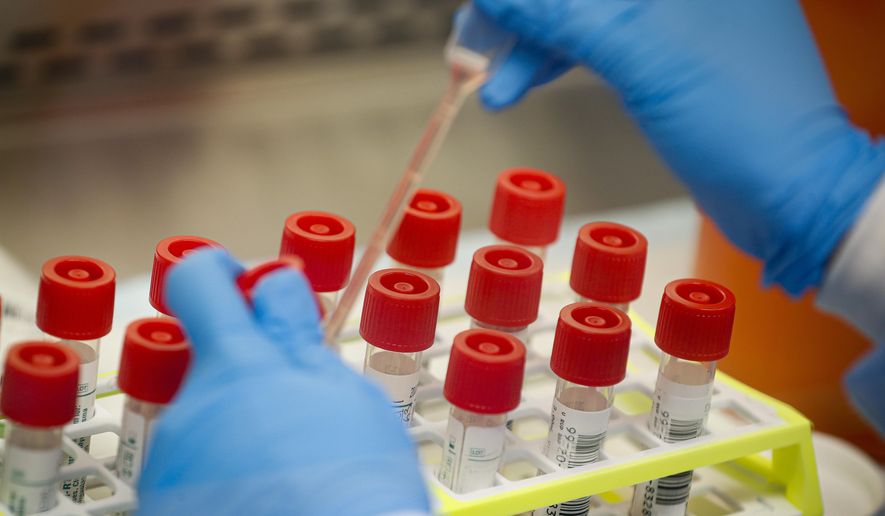 In this Wednesday, March 11, 2020, file photo, a technician prepares COVID-19 patient samples for testing at a laboratory in New York's Long Island. (AP Photo/John Minchillo) ** FILE **
