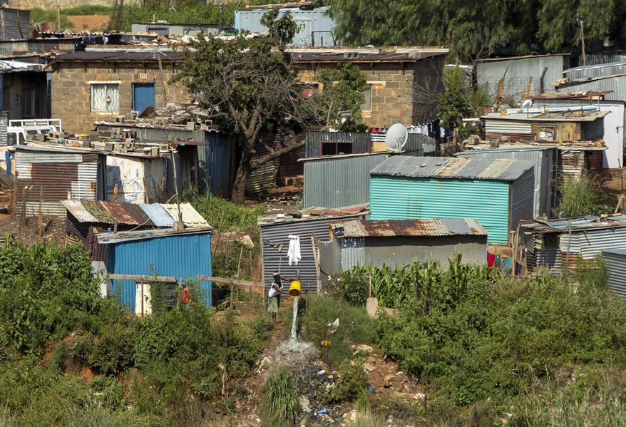 In this photograph taken Thursday March 19, 2020 , A woman spills water at squatter camp in Soweto, South Africa. Some countries around the world lack the equipment and trained health workers to respond to the threat of COVID-19 virus. For most people the virus causes mild or moderate symptoms, but for others it causes severe illness. (AP Photo/Themba Hadebe)