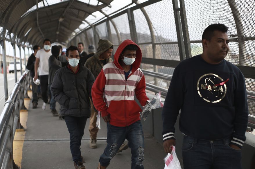 Central American migrants seeking asylum, some wearing protective face masks, return to Mexico via the international bridge at the U.S-Mexico border that joins Ciudad Juarez and El Paso, Saturday, March 21, 2020. Mexico and the U.S. are restricting travel over their busy shared border as they try to control the spread of the coronavirus pandemic. (AP Photo/Christian Chavez)