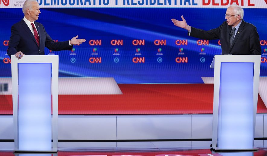 FILE - In this March 15, 2020, file photo former Vice President Joe Biden, left, and Sen. Bernie Sanders, I-Vt., right, participate in a Democratic presidential primary debate at CNN Studios in Washington. U.S. elections have been upended by the coronavirus pandemic. At least 13 states have postponed voting and more delays are possible as health officials warn that social distancing and other measures to contain the virus might be in place for weeks, if not months. (AP Photo/Evan Vucci, File)