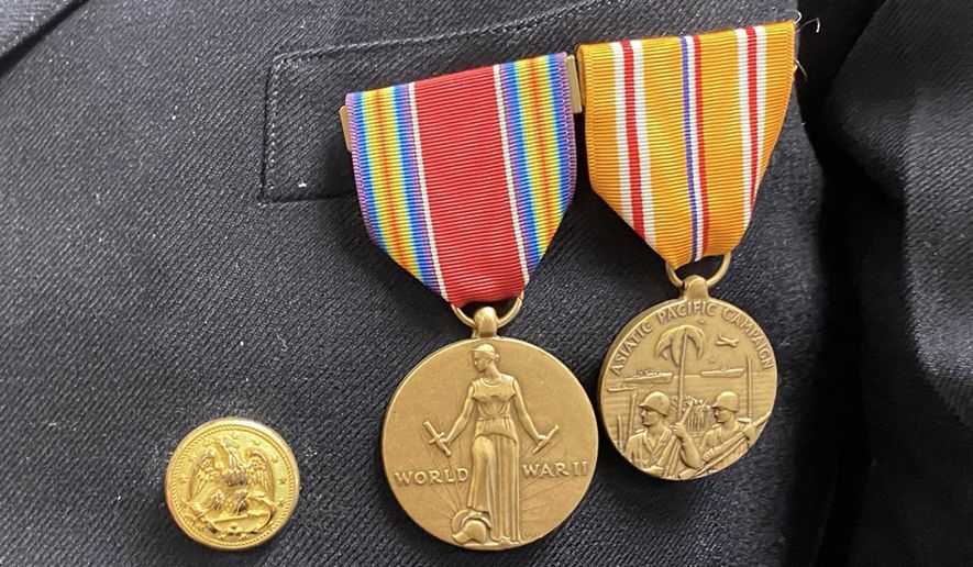 In this March 10, 2020 photo, WWII veteran Lester Clarke displays his medals in Aberdeen, S.D. Lester Clarke remembers how he had to sleep on the deck of a Navy ship during World War II because it was safer than in the ship's belly if a bomb or torpedo hit. (Kelda Pharris/Aberdeen American News via AP