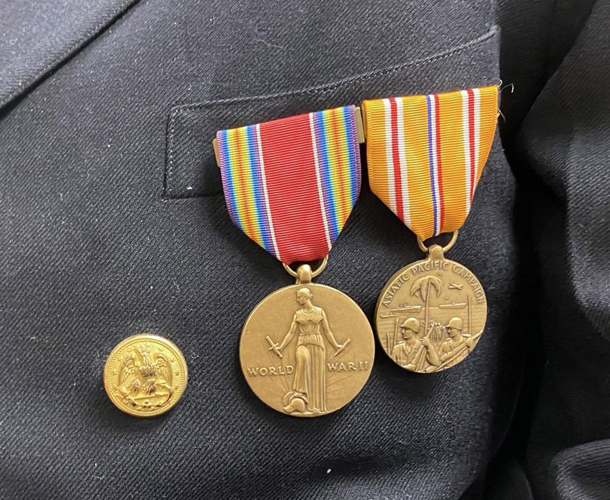 In this March 10, 2020 photo, WWII veteran Lester Clarke displays his medals in Aberdeen, S.D. Lester Clarke remembers how he had to sleep on the deck of a Navy ship during World War II because it was safer than in the ship's belly if a bomb or torpedo hit. (Kelda Pharris/Aberdeen American News via AP