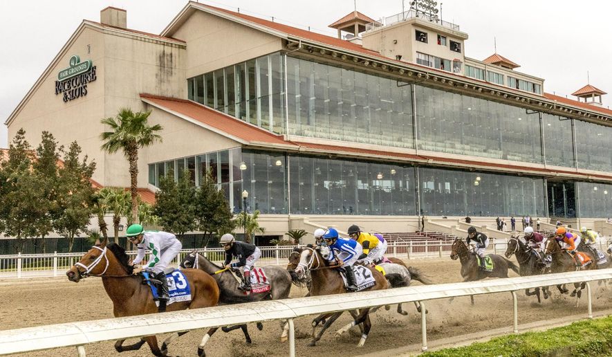 Wells Bayou, left, ridden by jockey Florent Geroux, took an early lead and held off NY Traffic to win he 107th running of the $1,000,000 Grade II Louisiana Derby horse race, Saturday, March 21, 2020, at a fanless Fair Grounds race course in New Orleans. (Amanda Hodges Weir/Hodges Photography, Fair Grounds Race Course via AP)