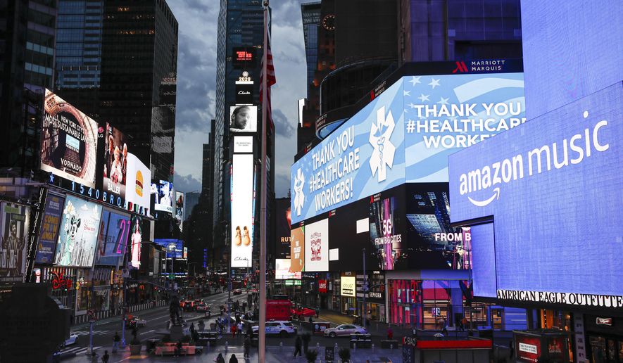 A screen displays a message thanking health care workers during the coronavirus outbreak, in a sparsely populated Times Square, Friday, March 20, 2020, in New York. New York Gov. Andrew Cuomo is ordering all workers in non-essential businesses to stay home and banning non-essential gatherings statewide. (AP Photo/John Minchillo)