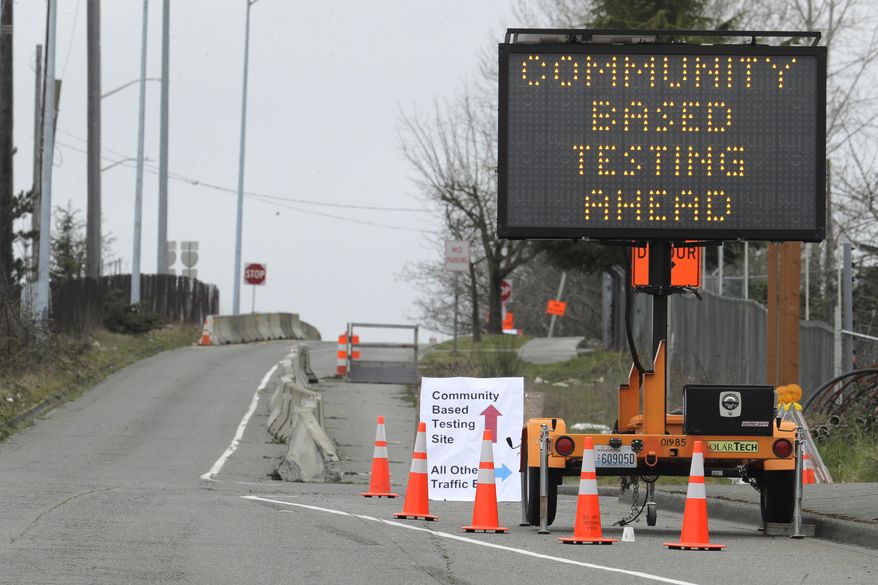 A sign directs vehicles toward a drive-up testing site at the Tacoma Dome in Tacoma, Wash., Saturday, March 21, 2020. The Tacoma-Pierce County Health Department is hosting the testing for the new coronavirus over the next several days for people at higher risk for COVID-19 and people with symptoms who work in healthcare, public safety, and for critical businesses such as grocery stores and public utilities. (AP Photo/Ted S. Warren)