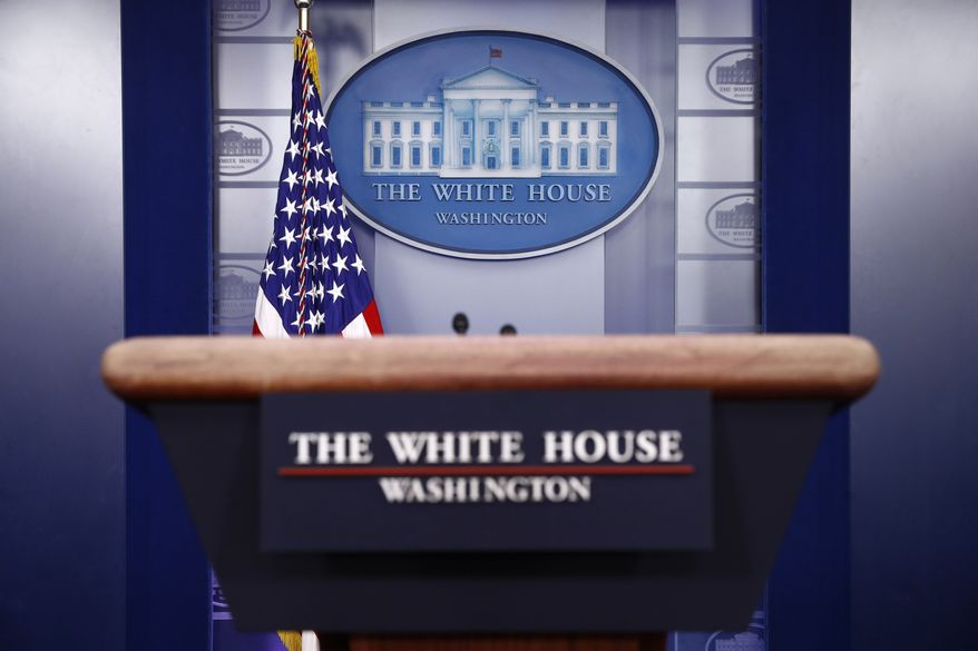 A plaque depicting the White House is posted behind a podium in the James Brady Press Briefing Room of the White House, Sunday, March 22, 2020, in Washington. (AP Photo/Patrick Semansky)