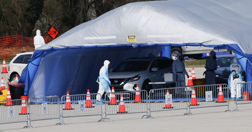Medical workers perform a coronavirus test on drivers at the Temple University Ambler campus in Ambler, Pa., Saturday, March 21, 2020. Montgomery County opened its first county-run drive-thru coronavirus testings site. (Yong Kim/The Philadelphia Inquirer via AP)