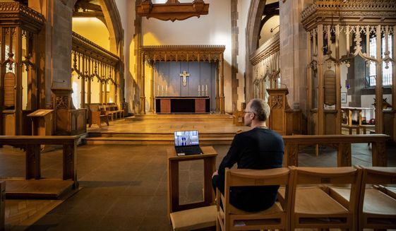 A church parishioner watches a laptop inside Liverpool Parish Church (Our Lady and St Nicholas) in Liverpool, England, during the Church of England&#39;s first virtual Sunday service given by the Archbishop of Canterbury Justin Welby, after the archbishops of Canterbury and York wrote to clergy on Tuesday advising them to put public services on hold in response to Government advice to avoid mass gatherings to help prevent the spread of the Covid-19 virus. For most people, the new coronavirus causes only mild or moderate symptoms. For some it can cause more severe illness. (Peter Byrne/PA via AP)