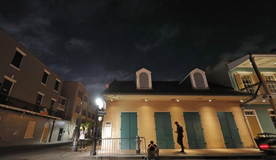 People are seen on Bourbon Street, which is normally bustling with tourists and revelers, in the French Quarter of New Orleans, Thursday, March 19, 2020. Louisiana Governor John Bel Edwards and New Orleans Mayor Latoya Cantrell have ordered all restaurants and bars to close except for takeout, and asked residents to remain home and maintain social distancing from others when outside, due to the COVID-19 virus pandemic. (AP Photo/Gerald Herbert)