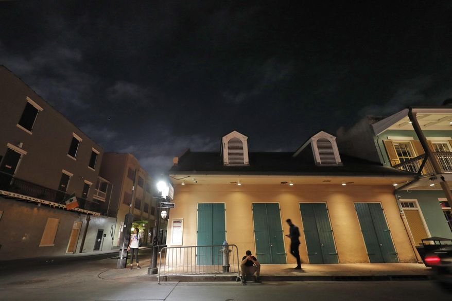 People are seen on Bourbon Street, which is normally bustling with tourists and revelers, in the French Quarter of New Orleans, Thursday, March 19, 2020. Louisiana Governor John Bel Edwards and New Orleans Mayor Latoya Cantrell have ordered all restaurants and bars to close except for takeout, and asked residents to remain home and maintain social distancing from others when outside, due to the COVID-19 virus pandemic. (AP Photo/Gerald Herbert)