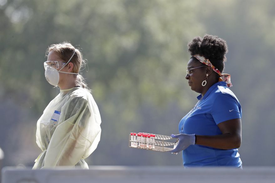 Supplies are moved to one of the stations at a coronavirus mobile testing site Monday, March 23, 2020, in The Villages, Fla. The Villages, a retirement community, is one of the largest concentration of seniors in the U.S. (AP Photo/John Raoux)