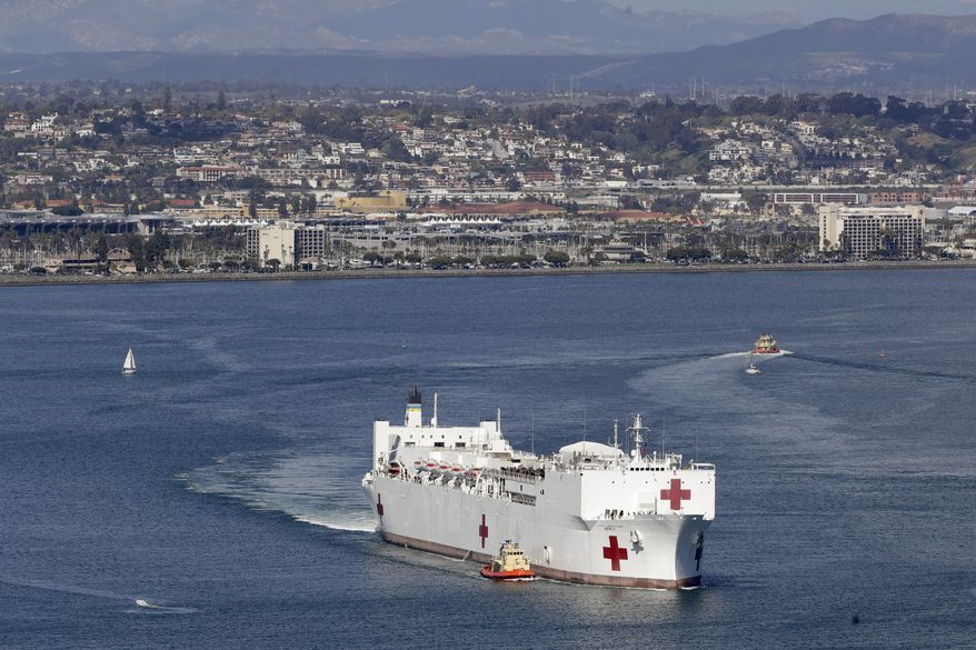 The USNS Mercy hospital ship leaves port Monday, March 23, 2020, in San Diego. The Navy hospital ship left San Diego on Tuesday and planned to spend a few days at sea getting its newly formed medical team used to working together before arriving to Los Angeles to help the city free up its hospital beds, in efforts to help combat the coronavirus. (AP Photo/Gregory Bull)