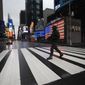 A man crosses the street in a nearly empty Times Square, which is usually very crowded on a weekday morning, Monday, March 23, 2020 in New York. Gov. Andrew Cuomo has ordered most New Yorkers to stay home from work to slow the coronavirus pandemic. (AP Photo/Mark Lennihan)  **FILE**