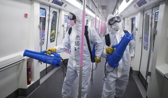 In this March 23, 2020, photo released by Xinhua News Agency, workers disinfect a subway train in preparation for the restoration of public transport in Wuhan, in central China&#39;s Hubei province. China&#39;s health ministry says Wuhan has now gone several consecutive days without a new infection, showing the effectiveness of draconian travel restrictions that are slowly being relaxed around the country. (Xiao Yijiu/Xinhua via AP)