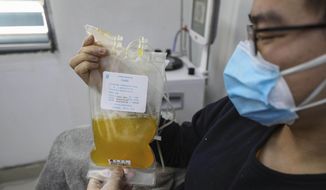 In this Feb. 18, 2020, file photo, Dr. Zhou Min, a recovered COVID-19 patient who has passed his 14-day quarantine, donates plasma in the city's blood center in Wuhan in central China's Hubei province. Plasma from recovered COVID-19 patients contains antibodies that may help reduce the viral load in patients that are fighting the disease. (Chinatopix via AP, File)